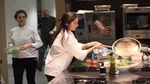 Women chef in industrial kitchen creating and serving a plant-based dish