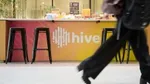 Person walking past counter with 'Hive' logo.